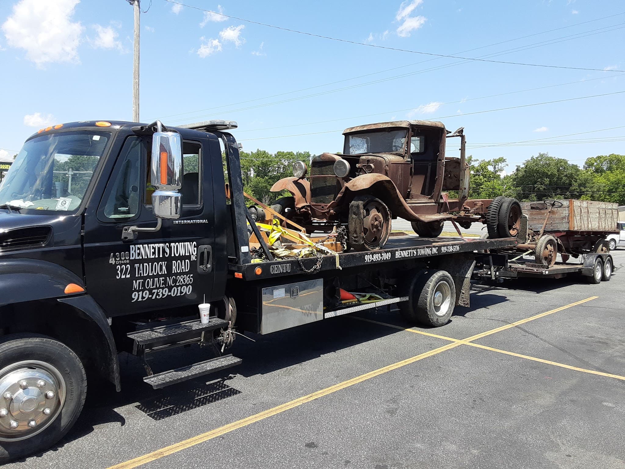 Stranded motorist on the phone calling Bennett's Towing next to a car with an open hood